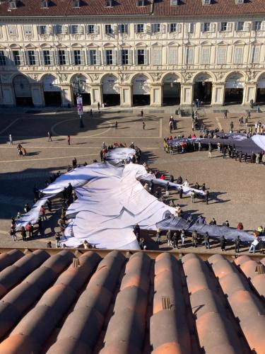 a large building with people sitting around a courtyard at San Carlo Suite Torino in Turin