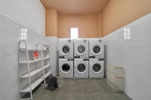 a laundry room with three washing machines in it at M Village Nguyễn Du in Ho Chi Minh City