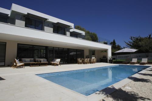 a house with a swimming pool in front of it at VILLA SP SUITES SANTA PONSA in Santa Ponsa