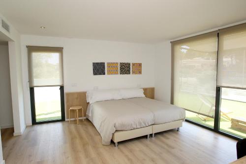 a bedroom with a bed and some windows at VILLA SP SUITES SANTA PONSA in Santa Ponsa