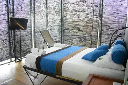 Kakulanda Resort في كورونيغالا: غرفة نوم بسرير وكرسي في غرفة
