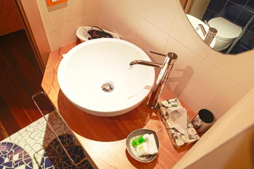 a bathroom with a white sink and a mirror at LA CASETTA NEI COLLI in Bergamo