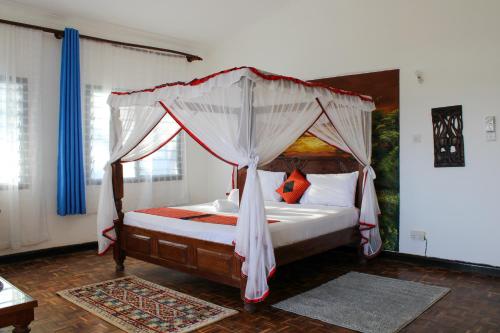 a bedroom with a bed with a canopy at Maasai Villas in Mombasa