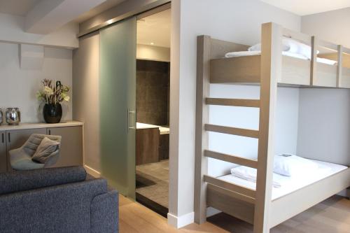 a room with a bunk bed and a bathroom at Hotel 't Peperhuys in Kaatsheuvel