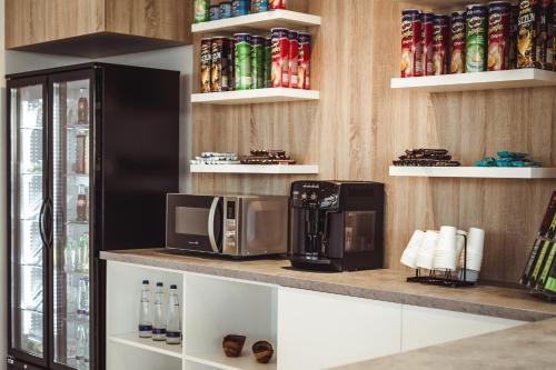 a kitchen with a microwave and a coffee maker on a counter at Wyndham Garden Munich Messe in Munich