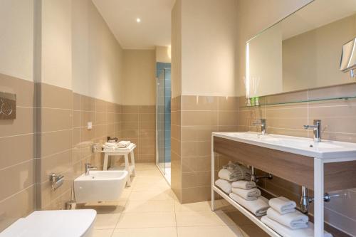 een badkamer met een wastafel en een toilet bij Isola di Albarella Hotel Capo Nord in Isola Albarella