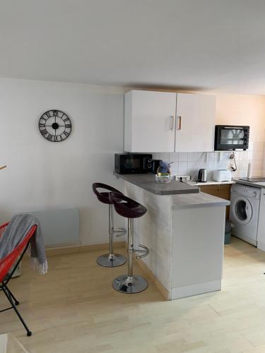 a kitchen with a counter and two bar stools at Cote Port in Le Crotoy