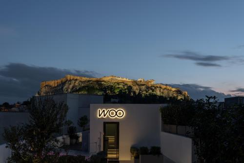 a building with the woco sign on it at night at Athens Woo Suites in Athens