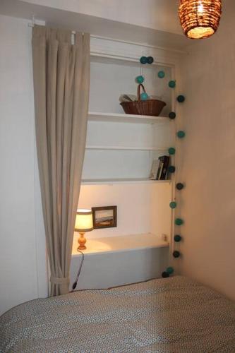 - une chambre avec une fenêtre dotée d'un rideau et d'une lampe dans l'établissement Escapade romantique et gourmande-St Malo, mer 150m, à Saint-Malo