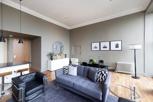 a living room with a couch and a table at JOIVY Chic 2BR Apt with City Views at the Heart of Old Town in Edinburgh