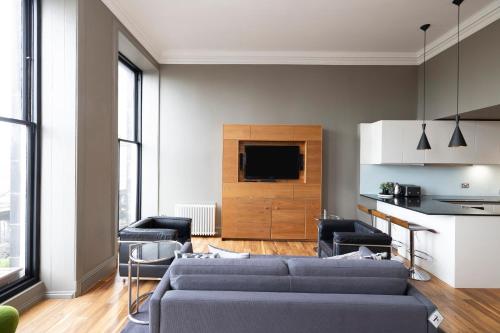 a living room with a couch and a tv at JOIVY Chic 2BR Apt with City Views at the Heart of Old Town in Edinburgh