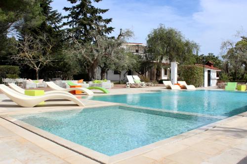 einen Pool mit Stühlen und einem Pool in der Unterkunft Diddy's Country - Abbasciu in San Vito dei Normanni