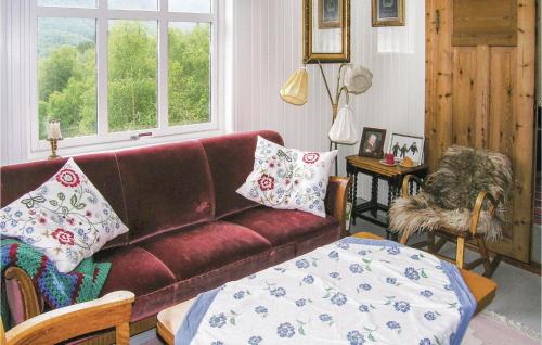 a living room with a red couch with pillows on it at Holiday Home Flekke Eldevik Ii in Flekke