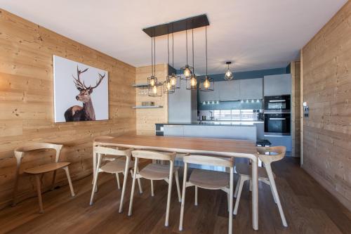 a dining room with a wooden table and chairs at Apartment Wapa Alpe d'Huez - by EMERALD STAY in L'Alpe-d'Huez