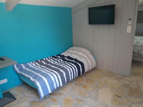 Sainte-Croix-de-QuintillarguesにあるLe clos des olivettesの壁にテレビが備わるドミトリールームのベッド1台分です。