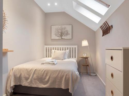 a white bedroom with a bed and a skylight at Pass the Keys Exceptional 3 Bedroom River View Apartment in Ulverston