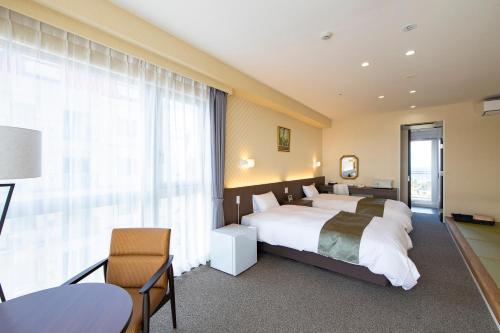 een slaapkamer met een bed en een groot raam bij Samson Hotel in Hirado