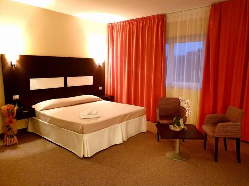 une chambre d'hôtel avec un lit et une chaise dans l'établissement Santa Loja Hotel Residence, à Tito