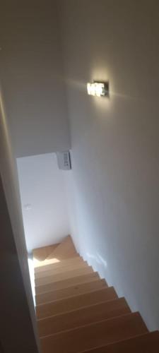 a staircase in a room with a light on the wall at Apartmani Lanterna in Krk