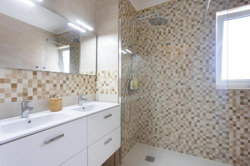 a bathroom with two sinks and a glass shower at Home2Book Chayofa Sunny Terrace & Pool in Arona