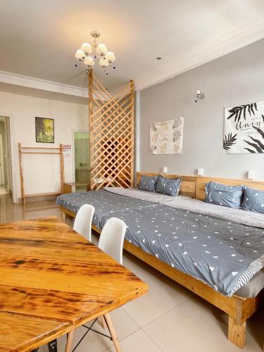 a bedroom with a large bed and a wooden table at Da Lat Lemongrass - Đà Lạt Sả in Da Lat