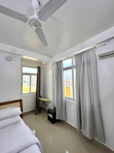 una camera con un letto e due finestre di One Room Private Apartment a Hulhumale