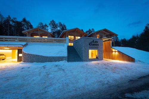 a building with a sign on it in the snow at Les Ciases Chalets Dolomites Apt 4 in San Vigilio Di Marebbe