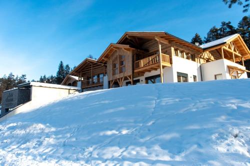 a house on top of a pile of snow at Les Ciases Chalets Dolomites Apt 4 in San Vigilio Di Marebbe