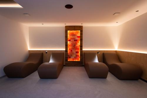 a waiting room with couches and a painting on the wall at Les Ciases Chalets Dolomites Apt 4 in San Vigilio Di Marebbe