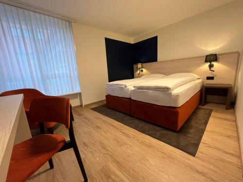 a hotel room with a bed and a desk at Dialoghotel Eckstein in Zug