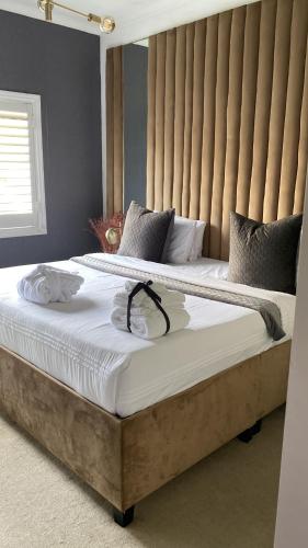 a bedroom with a large bed with a wooden headboard at Abusar Apartment in Boksburg