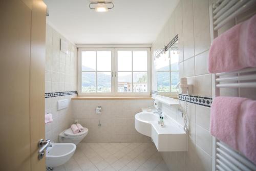 a bathroom with a sink and a toilet at Aktiv & Genusshotel Lodenwirt in Vandoies