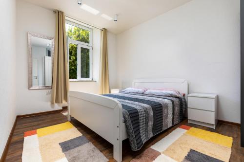 a white bedroom with a bed and a window at Apartments Smaila 1729 in Pula