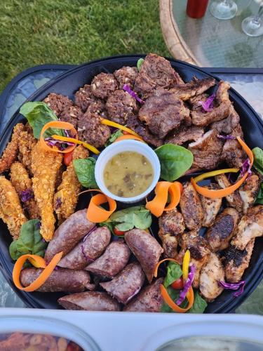 a plate of food with meat and vegetables on a table at Royal Highness Lux Guesthouse in Carletonville