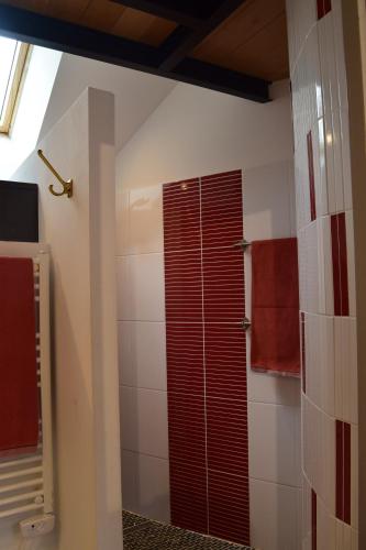 a bathroom with a shower with a red shutter at L'Aubergiste in Corcelles-les-Arts