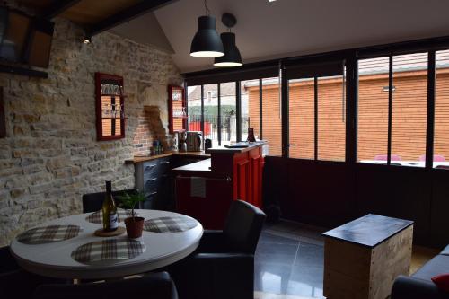 a kitchen with a table and chairs in a room at L'Aubergiste in Corcelles-les-Arts