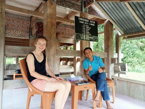 a man and a woman sitting in chairs at NUANSA HOMESTAY Authentic&Hospitality in Rantepao