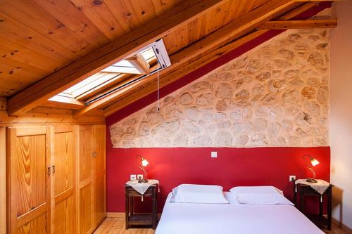 1 dormitorio con 1 cama grande y pared roja en Katouna Holiday House, en Katouna