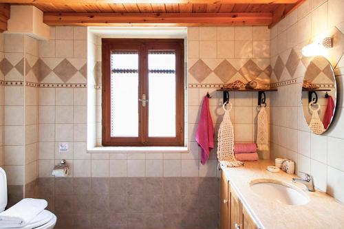 baño con lavabo y aseo y ventana en Katouna Holiday House, en Katouna