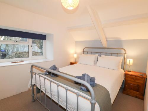a bedroom with a bed and a window at Little Barn Cottage in Newport Pembrokeshire