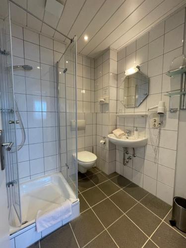 a bathroom with a tub and a sink and a toilet at Gästehaus Schmidt in Bad Lippspringe