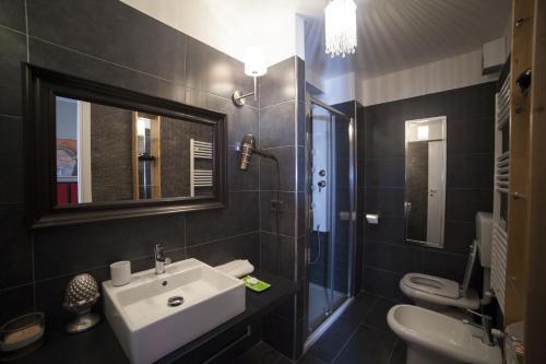 a bathroom with a sink and a toilet and a mirror at Residenze Torinesi in Turin