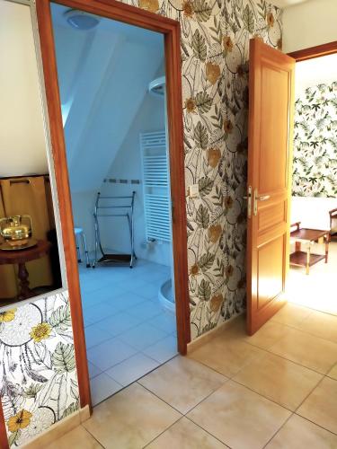 une porte menant à une chambre dotée de carrelage. dans l'établissement Petit Châtelet bis, à Hirel