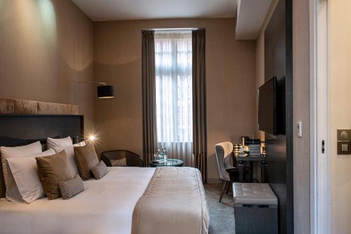 a hotel room with a bed and a window at La Cour des Consuls Hotel & Spa Toulouse - MGallery Collection in Toulouse