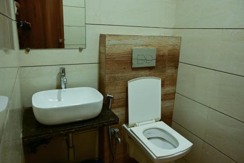 a bathroom with a white sink and a toilet at Hotel Diamora Residency in Thane