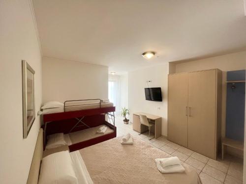 ミラノ・マリッティマにあるHotel Rosen Gardenのベッドとデスクが備わる客室です。