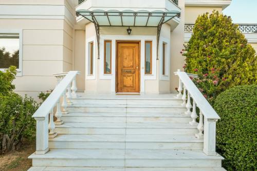 a staircase leading to a house with a wooden door at Supreme and Classy Pool Residence in Paianía