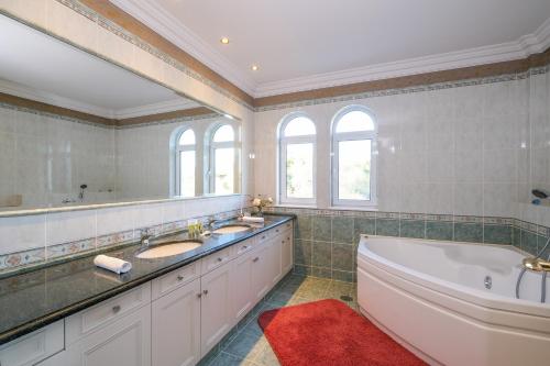 un ampio bagno con due lavandini, una vasca e una vasca da bagno di Supreme and Classy Pool Residence a Paianía