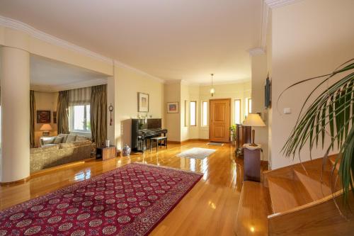 un soggiorno con divano e tappeto rosso di Supreme and Classy Pool Residence a Paianía