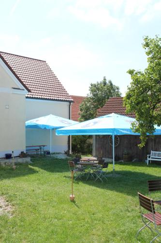 a patio with blue umbrellas and a table and chairs at Landgasthof Weberhans in Harburg